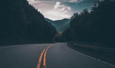 a closeup photo of a road with mountains on either side