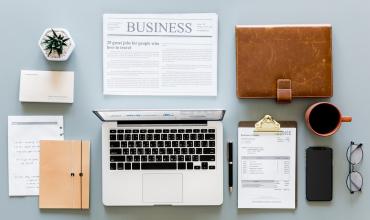 a workspace with a computer and notepad