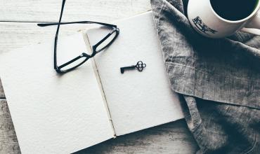 A key and a pair of glasses on top of a book