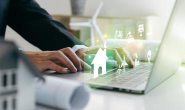 A person sitting on this computer with fictional houses coming out of the computer