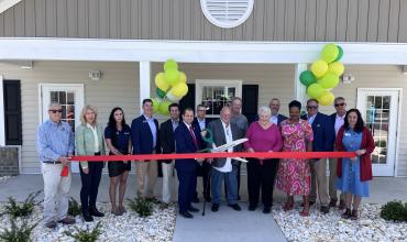 Group of people cutting a ribbon