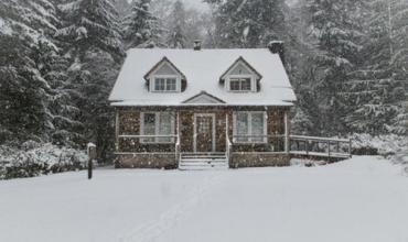 A small house surrounded by snow