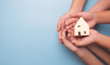 Is Your Home Ready for an Emergency? Hands holding a little house against a blue background