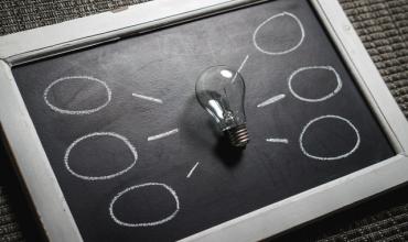 Lightbulb laying on a chalkboard