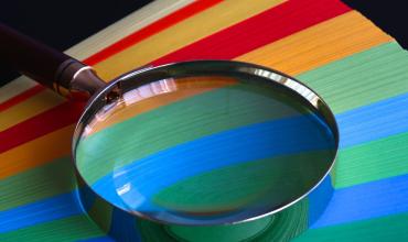 Magnifying glass over colored paper