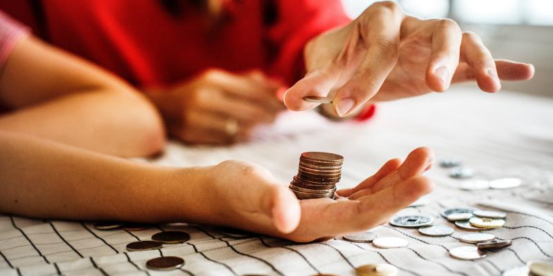 hands on a table holding coins