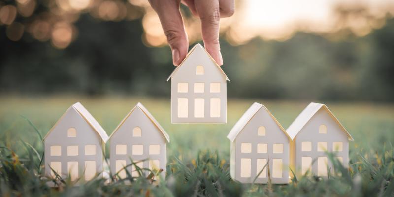 Supreme Court Ends Eviction Moratorium A paper house being placed on grass by a hand