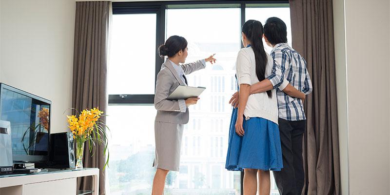 a realtor showing a couple the amenities of a new home