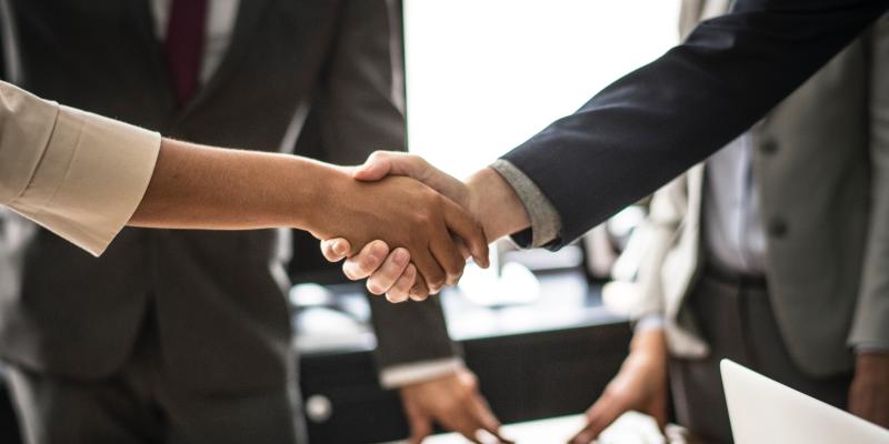 two real estate agents and their clients shaking hands