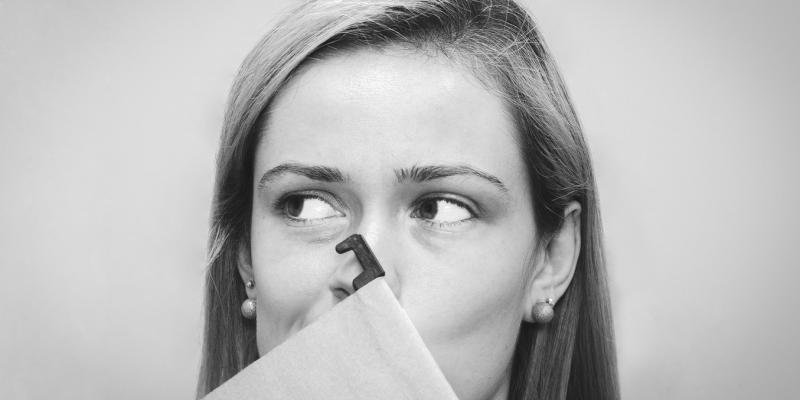 A woman holding a folder in front of her face 