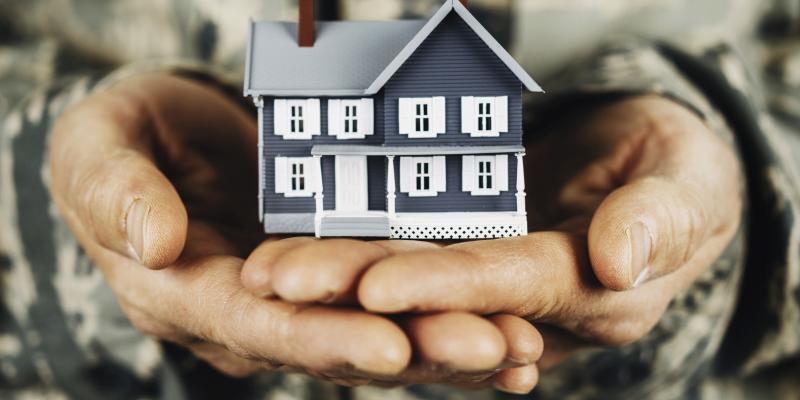 veteran holding a toy house