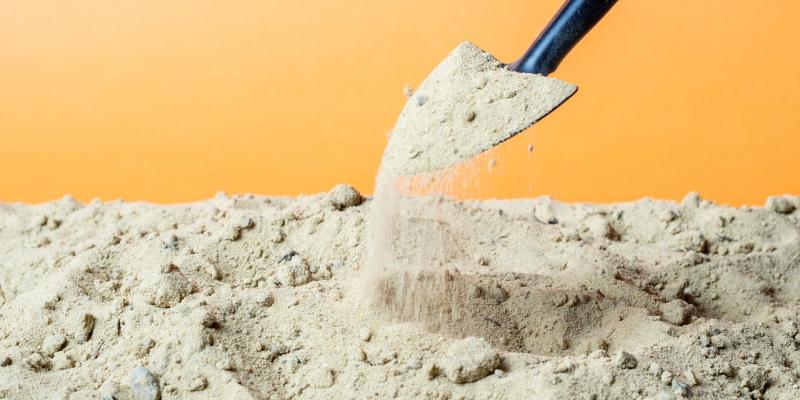 Shovel picking up dirt with a yellow background