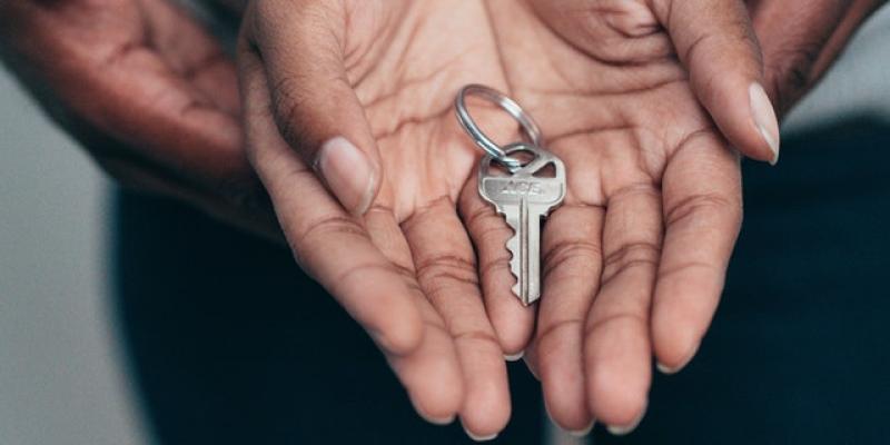 Two hands holding house keys