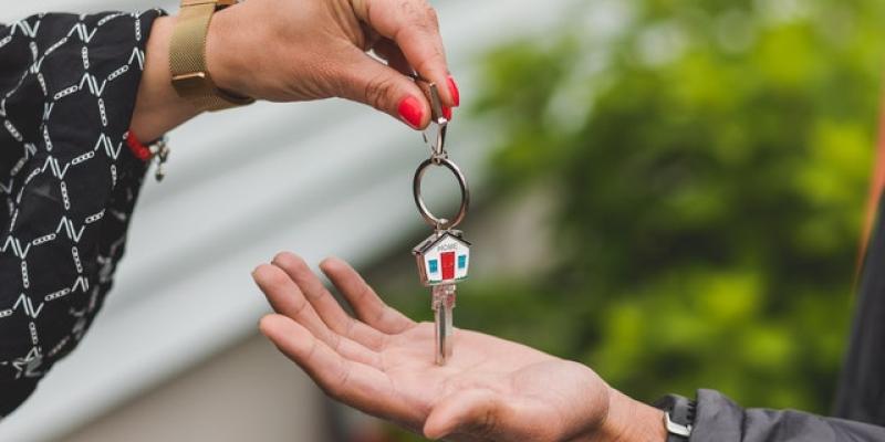 Your Home Awaits: June is Home Ownership Month A hand placing a key in another person's hand