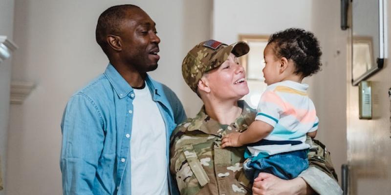 A man with his military wife holding their child