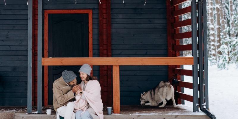Four Reasons Why You Should Buy a Home for the Holidays A couple holding hands on their front porch in the winter